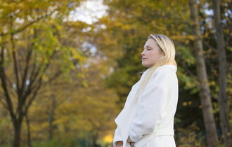Pretty blonde woman with coat in Park in Autumn