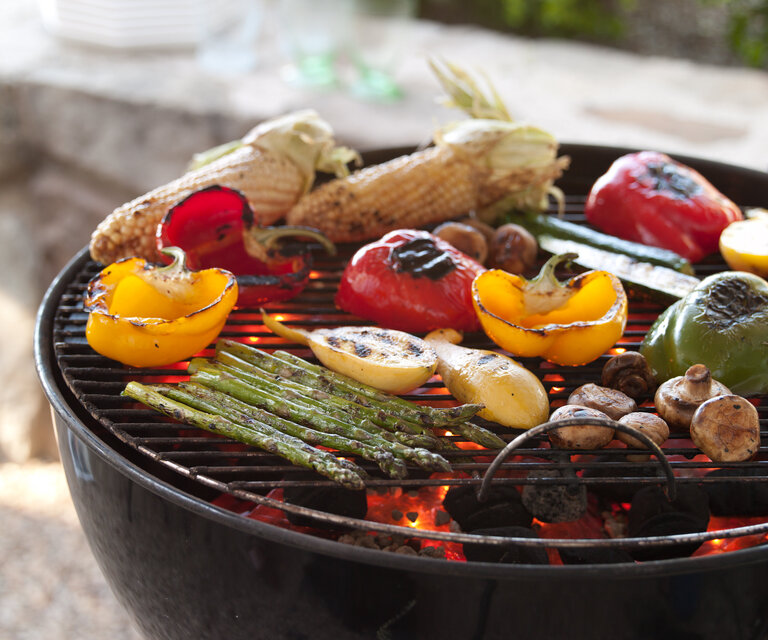 Various grilled vegetables on a barbecue.