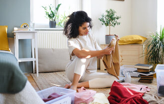 Young,Woman,Sorting,Wardrobe,Indoors,At,Home,,Charity,Donation,Concept.