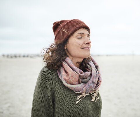 Portrait of smiling woman with closed eyes on the beach