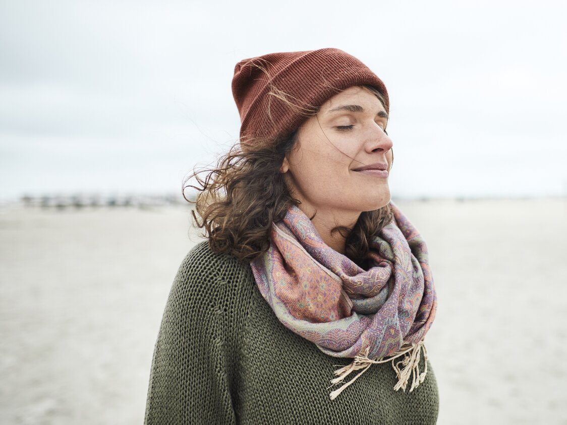 Portrait of smiling woman with closed eyes on the beach