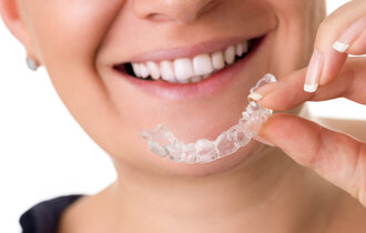 Woman,With,Perfect,Teeth,Holding,Invisible,Braces,,Correction,Teeth,Braces