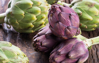 Green,And,Purple,Artichoke,Flower,Edible,Buds,On,Wooden,Background.