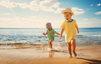 Boy,And,Girl,Playing,On,The,Beach,On,Summer,Holidays.