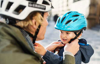 Erwachsener mit Kind mit Fahrradhelm