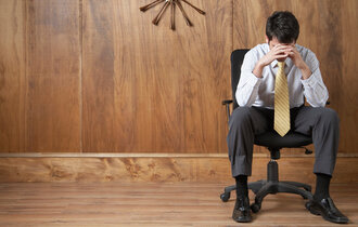 Businessman Sitting Alone in Wood-paneled Room