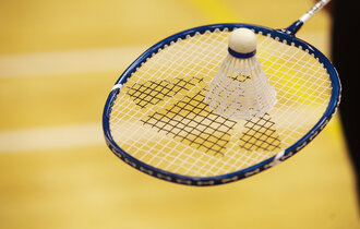 Shuttlecock on top of badminton racket