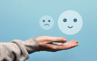 A,Sad,And,Joyful,Face,In,The,Hand,Of,A