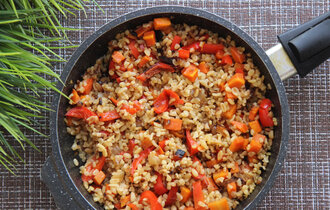  Eine Pfanne mit Bulgur und Paprikastücken. Daneben Schnittlauch.