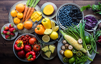 Obst und Gemüse in vielen verschiedenen Farben liegen auf diversen Tellern.